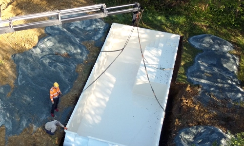 A crane delivering a pool for an ourdoor pool installation